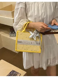 Yellow canvas tote bag with star print and fashion bag stripe design for women daily use.