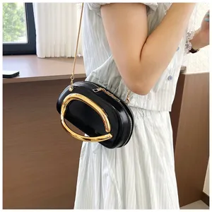 Élégant sac bandoulière noir pour femme avec poignée métallique dorée audacieuse et chaîne.