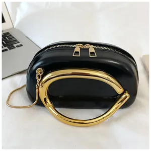 Sac bandoulière noir élégant avec poignée en métal doré audacieuse et chaîne pour femmes.