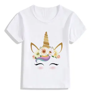 Primo piano di t-shirt bianca per bambini con corno d'unicorno dorato e corona floreale.