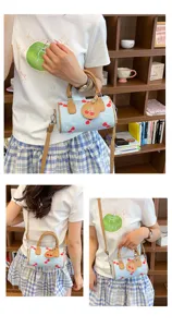 Chic denim cherry print barrel bag detail, stylish crossbody handbag showcasing cute design.