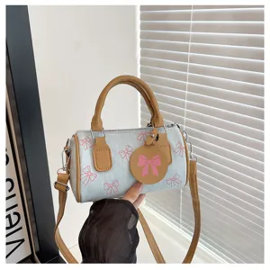 Cute denim bow print cylindrical handbag, stylish women's shoulder crossbody bag detail.