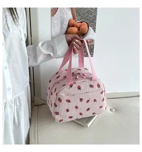 Detailansicht der süßen Cord Lunchtasche mit Erdbeermuster für den täglichen Gebrauch.