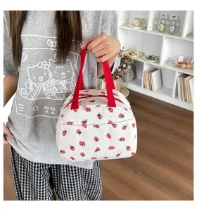 Detailansicht der weißen Kord Erdbeer Lunchtasche mit roten Griffen für den Alltag.