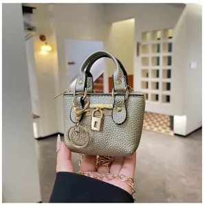 Nahaufnahme Detail einer metallischen goldenen Mini-Handtasche mit Schloss und Kette.
