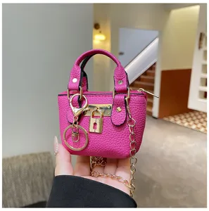 Rosa Mini Handtasche Detail zeigt strukturiertes Kunstleder mit Metallschloss und Kette.