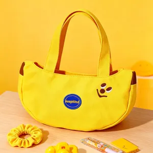Cute yellow banana shape canvas handbag for women, casual commuting tote bag with fun embroidery design.