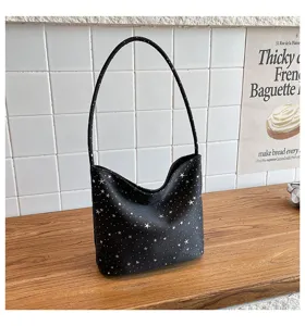 Detailed view of the black star print shoulder bag, showing fabric texture and strap design.