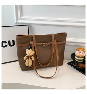 Fashionable brown PU leather tote bag with double straps and cute bear pendant for women.