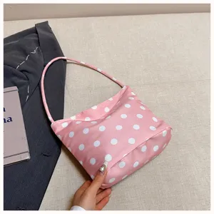 Close-up view of the stylish pink polka dot underarm shoulder bag showcasing its neat fabric texture.
