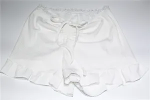 Vue détaillée short blanc côtelé à volants, vêtement détente femme été décontracté.