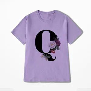 Detailopname van het paarse korte mouw t-shirt met bloemige letter Q grafische print.