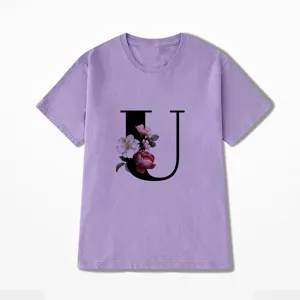 Close-up van het florale letter U detail op de paarse korte mouw t-shirt stof.