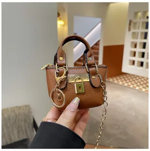 Detailansicht der kleinen braunen Lederhandtasche mit edlem Metallschloss für stilvolle Kinder.