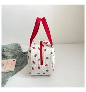 Detailansicht der weissen Cord Tasche mit rotem Reissverschluss und roten Griffen.