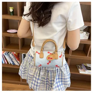 Cute denim cherry print cylindrical shoulder bag for women, trendy casual crossbody handbag.
