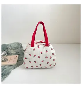 Detailansicht der niedlichen Kord Erdbeer-Lunchtasche mit roten Henkeln und frischem Design.