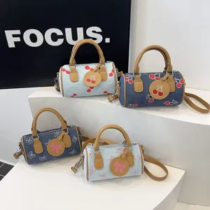 Cute denim barrel bag with cherry and bow prints, stylish shoulder crossbody bag for women.