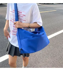 Detail view of large capacity blue shoulder bag, casual messenger bag for daily commuting style.