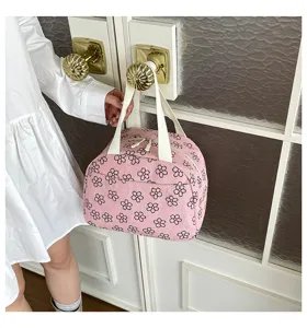 Détail de sac à lunch en velours côtelé rose, joli design imprimé floral avec poignées.