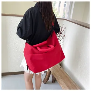 Detail view of the large red sports duffel bag worn over the shoulder for daily use.