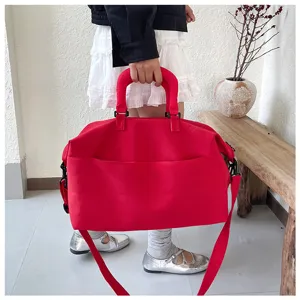 Red large capacity fitness travel duffel bag detail, thick handle and shoulder strap.