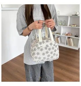 Détail de sac à lunch en velours côtelé avec motif floral noir et blanc et texture de tissu.