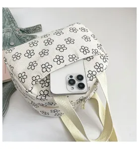 Vue détaillée du sac à lunch en velours côtelé avec motif floral et poche avant pratique.