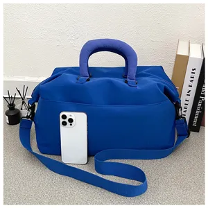 Detailed view of the blue travel duffel bag with shoulder strap and props in scene.