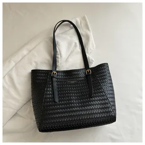 Bolso tote trenzado negro con correas, diseño elegante para uso diario y desplazamientos.