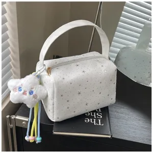 Detail shot of white star print handbag with cute plush cloud charm, stylish daily cosmetic bag.