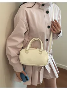 Detailed view of the stylish cream Boston handbag, showing its smooth texture and design.