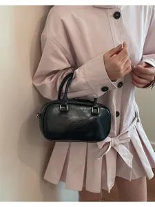 Black Boston handbag detail view, classic bowling bag design with dual top handles.
