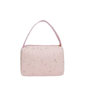 Pink cosmetic bag with silver star print, top handle and zipper for daily travel storage.