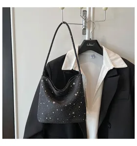Detailed view of black underarm shoulder bag with silver star prints, chic and stylish.