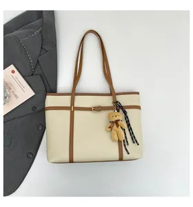 Detail view of stylish casual large-capacity shoulder tote bag with cute bear charm.