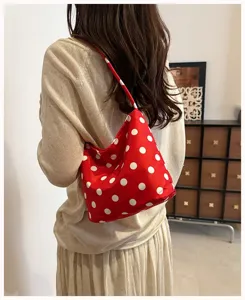 Detailed view of trendy red polka dot shoulder underarm bag, casual everyday style.