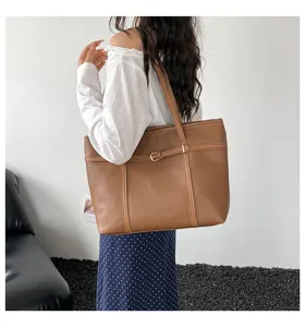 Large brown leather tote bag detail, stylish shoulder bag with buckle strap for women summer.