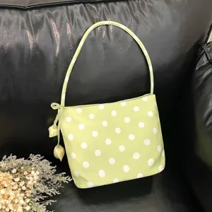 Detail shot of the light green polka dot shoulder bag, showing fabric texture and cute side bow.