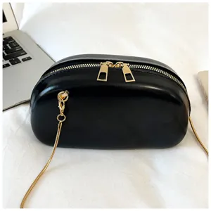 Gros plan sur le sac à main rugby noir avec des fermetures éclair dorées et une chaîne élégante.
