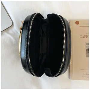 Vue détaillée d'un sac bandoulière en cuir noir élégant avec fermetures métalliques.