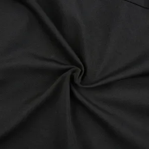 Primer plano detallado del tejido de falda negro con textura de sarga fina y calidad.