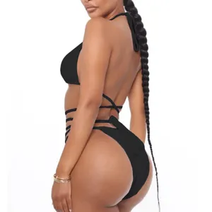 Close-up detail of the black strappy bikini showing the side wrap ties and high cut design.