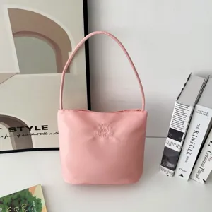 Detalle del bolso de hombro de nylon rosa con bordado Love and Fearless y textura de tela limpia.