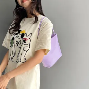Primer plano del elegante bolso de hombro de nylon morado llevado por modelo, casual.