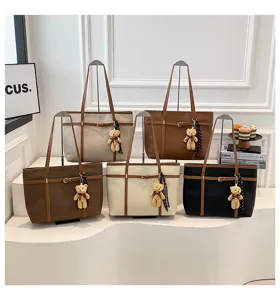 Details of stylish large capacity tote bag with teddy bear pendant and chic design for women.