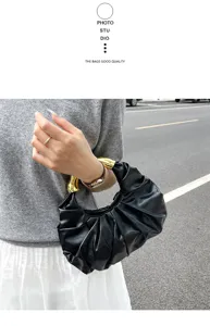 Elegante schwarze gefaltete Handtasche mit goldenem Griff, modernes Nischendesign.