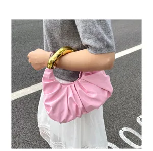 Detailansicht einer rosa plissierten Handtasche mit glänzendem Metallgriff für den Alltag.