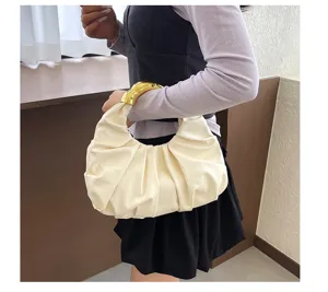 Weißes Plissiertes Knödelhandtaschen-Detail mit elegantem, schlaffem Design und schickem Goldgriff.