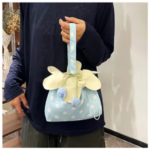 Primo piano di una borsa in tessuto a pois in stile coreano con coulisse e dettagli.